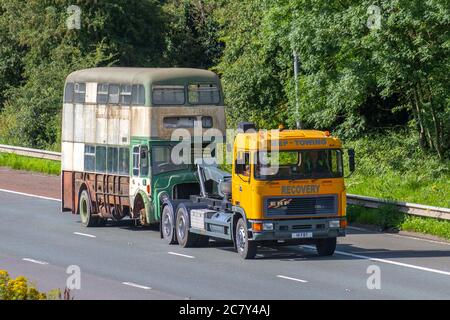 MEP Recovery 1967 60s Leyland Titan Bus (Frontmotor-Doppeldecker mit 1993 ERF-Schlepper, zur Restaurierung abgeschleppt. Der Zustand des Fahrzeugverkehrs in Großbritannien ist heruntergekommen, seltener Sammeltransport im klassischen Oldtimer auf dem Schlepp, verrostete alte Busse, Doppeldecker-Klassiker in nördlicher Richtung auf der Autobahn M6. Stockfoto