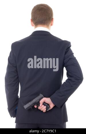 Mann in Business-Anzug versteckt Waffe hinter seinem Rücken isoliert auf weißem Hintergrund Stockfoto