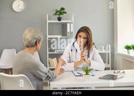 Reife Frau im Gespräch mit Arzt in der Klinik. Leitender Patient, der vom Arzt im Krankenhaus konsultiert wird Stockfoto