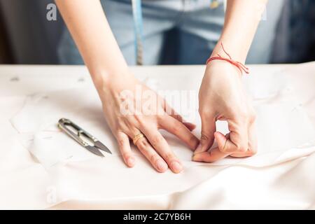 Schneiderei macht ein Muster . Nähmaschine steht auf dem Tisch neben ihnen. Stockfoto