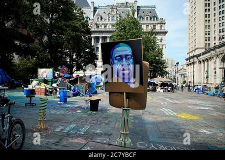 New York, Usa. Juli 2020. In der Mitte der Zone befindet sich eine künstlerische Darbietung von George Floyd.Mehr als einen Monat nachdem Demonstranten einen kleinen Park in der Nähe des Rathauses, das Occupy City Hall genannt wird, übernahmen, um die Definanzierung der New Yorker Polizeibehörde zu fordern, Das Lager bleibt eine feste Größe in der Gegend. Während die meisten Demonstranten das Lager verlassen haben, malen Künstler weiterhin Wandgemälde und hinterlassen Botschaften auf dem Bürgersteig. Kredit: SOPA Images Limited/Alamy Live Nachrichten Stockfoto