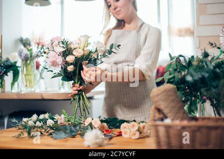 Kleine Unternehmen. Männliche florist unfocused im Blumengeschäft. Floral Design Studio, Dekorationen und Arrangements. Blumen Lieferung, die Ordnung Stockfoto