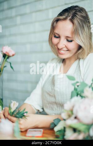 Kleine Unternehmen. Männliche florist unfocused im Blumengeschäft. Floral Design Studio, Dekorationen und Arrangements. Blumen Lieferung, die Ordnung Stockfoto