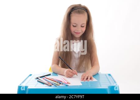 Kleines Mädchen Zeichnung mit Farbstiften isoliert auf weißem Hintergrund Stockfoto