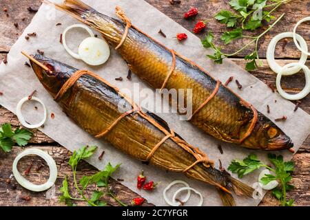 Geräucherter Hering auf Holzgrund mit Gemüse und Gewürzen Stockfoto