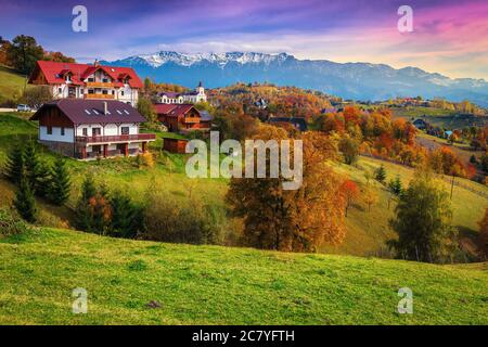 Beliebte ländliche touristische Orte mit spektakulären Gärten und hohen schneebedeckten Bergen im Hintergrund. Herbstlandschaft mit Laubbäumen und Häusern auf Th Stockfoto