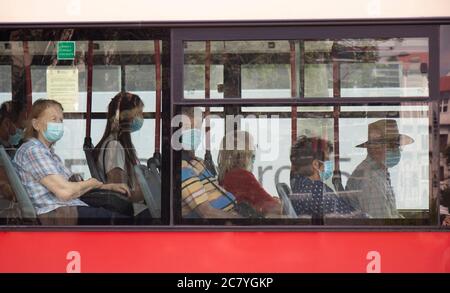 Belgrad, Serbien - 16. Juli 2020: Menschen mit chirurgischen Gesichtsmasken, während sie auf einem Fenstersitz eines fahrenden Busses sitzen und reiten, von außen Stockfoto