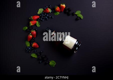 Flasche auf Rahmen von Erdbeeren, Minze, Brombeeren und Heidelbeeren. Draufsicht, Rahmen Stockfoto
