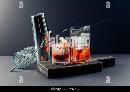 Rotes Getränk mit Eis. Cocktailbar Werkzeuge, Erdbeer und Orangenschale Stockfoto