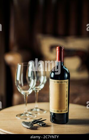 Rotwein-Flasche und Weinglas auf Wodden Tisch Stockfoto