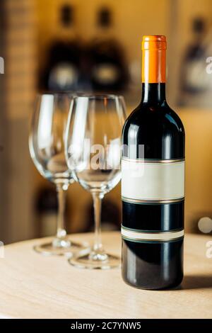 Rotwein-Flasche und Weinglas auf Wodden Tisch Stockfoto