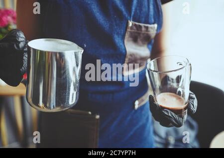 Barista macht rosa Matcha Latte mit Milch. Barkeeper bereitet leckere Getränk.verschwommenes Bild, selektiver Fokus Stockfoto