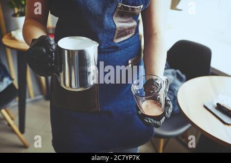 Barista macht rosa Matcha Latte mit Milch. Barkeeper bereitet leckere Getränk.verschwommenes Bild, selektiver Fokus Stockfoto