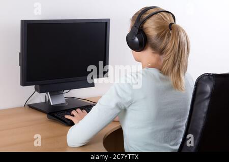 Junge Frau mit PC und Musik hören Stockfoto