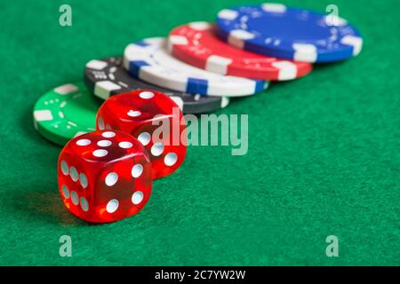 Rote Würfel auf einem Casino-Tisch mit bunten Chips Stockfoto