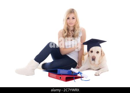 Junge schöne Frau mit Hund in Studentenhut auf weißem Hintergrund isoliert sitzen Stockfoto