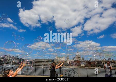 Ein Seifenblasenkünstler unterhält Menschen mit riesigen Blasen, St Paul's Cathedral im Hintergrund, London, Großbritannien Stockfoto