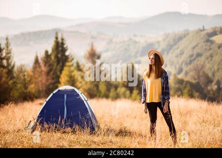 Junge Frau Tourist in der Nähe Zelt auf der Oberseite der Berge Waldlandschaft genießen Freiheit in Camp Ferien Stockfoto