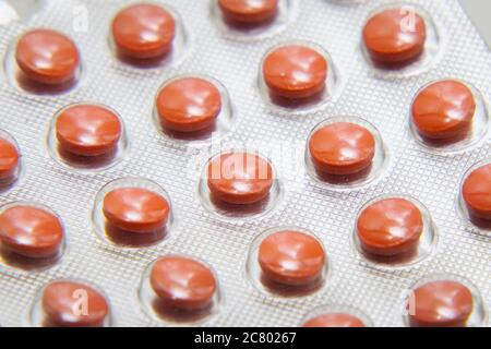 Blister mit Tabletten Nahaufnahme auf grauem Hintergrund. Pharmazeutischer oder medizinischer Hintergrund Stockfoto