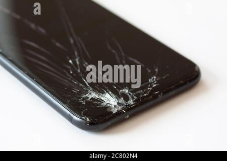 Ecke des Mobiltelefons mit defekter Anzeige nach dem Ablegen. Abgestürzt schwarzen Smartphone Nahaufnahme. P erblicktes Bild auf weißem Hintergrund. Stockfoto