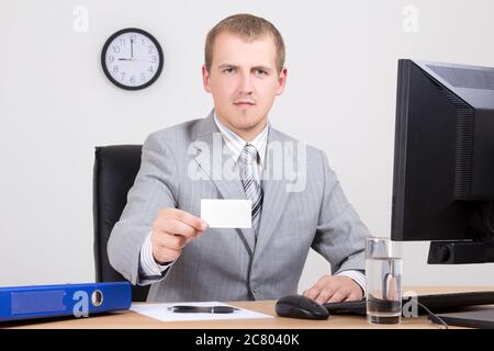 Junger Geschäftsmann bietet Karte in seinem Büro Stockfoto