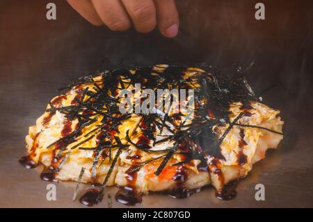 Japanische Pizza Okonomiyaki Kochen auf heißen Teller Teppanyaki Stil. Stockfoto