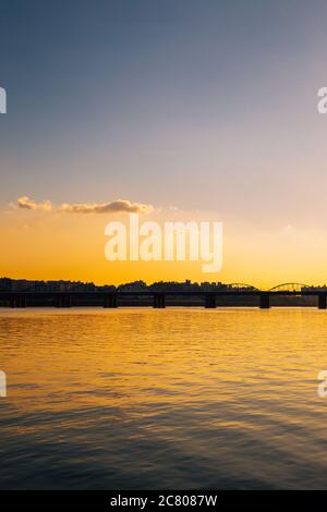 Dongjak-Brücke und modernes Stadtbild mit Han-Fluss unter dramatischem Sonnenuntergang Himmel vom Banpo Hangang Park in Seoul, Korea Stockfoto