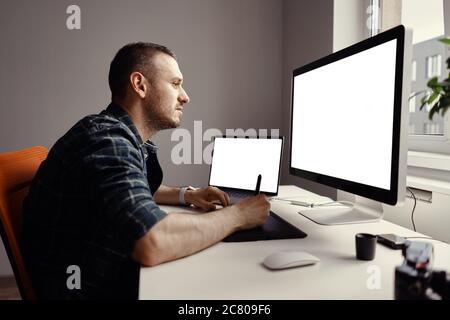 Grafikdesigner Arbeiten mit interaktivem Stift-Display, digitalem Zeichentablett und Stift auf einem Computer mit leerem Monitor Stockfoto