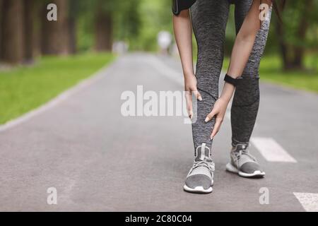 Junge Läuferin leidet an Schienbeinen beim Joggen im Park Stockfoto