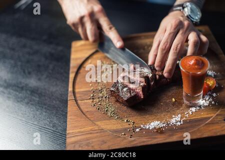 Messer schneiden eingelegte Gurke. Gemüse in Scheiben auf Holzbrett. Zutat für salzigen Salat Stockfoto
