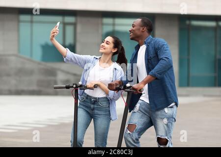 Paar mit Fahrt auf motorisierten Kick Scooter, Selfies Stockfoto