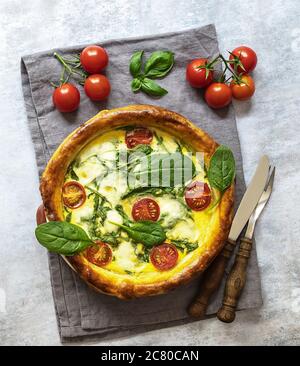 Vegetarische Quiche mit Spinat, Feta, Mozzarella und Tomaten Kirsche. Stockfoto