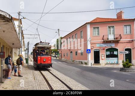 SINTRA, PORTUGAL - 12. Juni 2017. Touristen steigen in eine alte rote Straßenbahn auf den Straßen von Sintra. Alte Straßenbahnen sind eine der vielen Attraktionen in Sintra Stockfoto