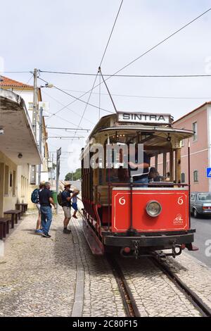 SINTRA, PORTUGAL - 12. Juni 2017. Touristen steigen in eine alte rote Straßenbahn auf den Straßen von Sintra. Alte Straßenbahnen sind eine der vielen Attraktionen in Sintra Stockfoto