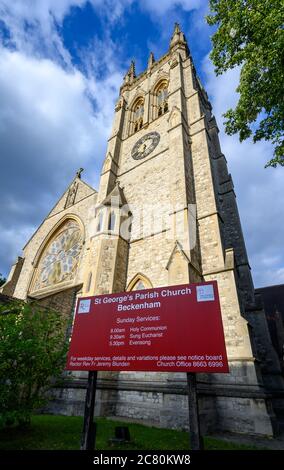 Beckenham (Großraum London), Kent, Großbritannien. St. George's Church in Beckenham mit quadratischem Kirchturm, kreisförmigem Buntglasfenster und Schild. Stockfoto