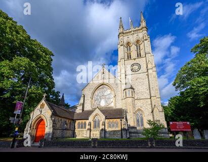 Beckenham (Großraum London), Kent, Großbritannien. St. George's Church in Beckenham mit quadratischem Kirchturm, kreisförmigem Buntglasfenster und Schild. Stockfoto