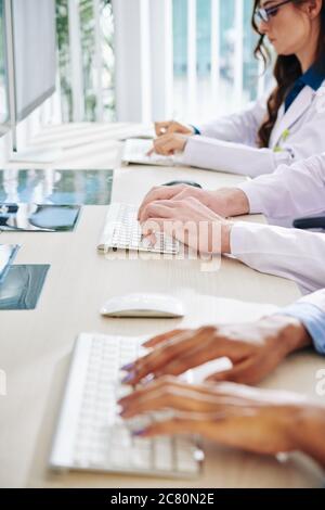 Nahaufnahme von Wissenschaftlern oder Ärzten, die an Computern arbeiten und Forschungsergebnisse einliefern Stockfoto