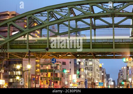 Akihabara Electric Town, Tokyo, Kanto Region, Honshu, Japan - Zug auf Hochbrücke und beleuchtete Gebäude. Stockfoto