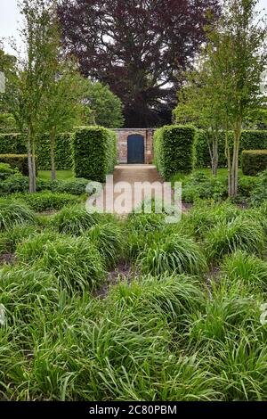 Blick auf die Drifts von Grass Garden innerhalb der ummauerten Garten des herrschaftlichen Regency-Hauses Scampston Hall im Norden Yorkshire Stockfoto