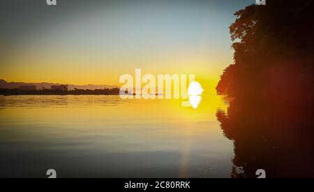 Sonnenaufgang Sonnenuntergang am Fluss 'Canal do estuário', zwischen den Städten Guaruja und Bertioga in Brasilien. Farbenfrohe und ruhige Sonnenaufgänge an einem ruhigen Fluss. Sli Stockfoto