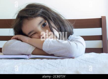 Grundschülerin macht ihre Hausaufgaben. Sie macht ihre eigenen Hausaufgaben allein zu Hause, weil die Schulen wegen der Corona pandemi geschlossen sind Stockfoto