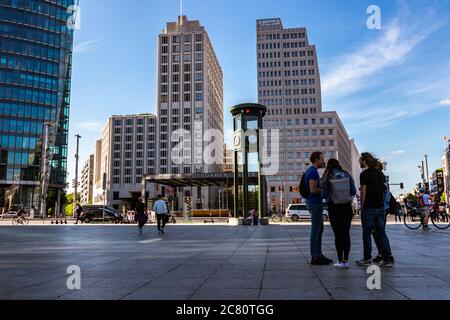 Berlin, Deutschland - 21. Juni 2020 - Touristen am berühmten Berliner Potsdamer Platz und im berühmten The Ritz-Carlton Hotel im Hintergrund an einem sonnigen Tag Stockfoto