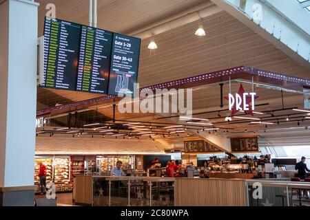 Der Pret A Manger, internationales Sandwich-Diner und im Vordergrund eine Abflugsanzeige in der Abflughalle am Flughafen Stansted. Stockfoto