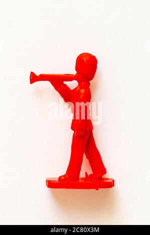 Airfix 1960 HO/00 Figur aus der Guards Band Serie. Spielzeugguardsman marschiert und spielt die Trompete, in rotem Kunststoff modelliert. Weißer Hintergrund. Stockfoto