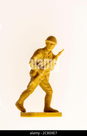 Airfix HO/00 Modell japanische Soldaten Figur aus den 60er Jahren vor einfachem Hintergrund. Nahaufnahme des vorrückenden Soldaten des 2. Weltkrieges, der die Waffe hält. Stockfoto