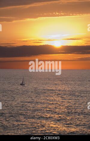 Kleines Segelboot auf dem Meer bei Sonnenuntergang Stockfoto