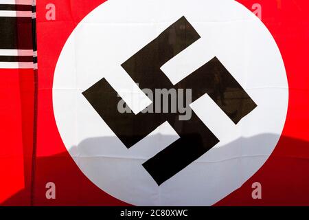 Nahaufnahme der Nazi-Flagge. Schwarzes Hakenkreuz gegen runde weiße Wand auf rotem Hintergrund. Stockfoto