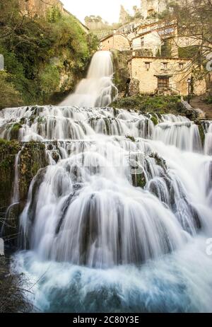 Vertikale Low-Angle-Aufnahme der schönen Orbaneja del Castillo Wasserfall in Burgos Stockfoto