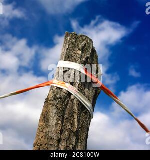 Rot-weißes Warnband, das sich über einen wolkigen Himmel streckte Stockfoto