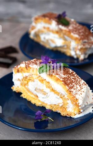 Schweizer Brötchen mit Sahne, ein Stück hausgemachter Kuchen auf einem Teller. Stockfoto